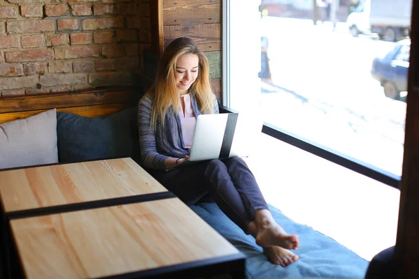 Glad girl sitting near of coffee and notebook in luncheonette. — Stock Photo, Image