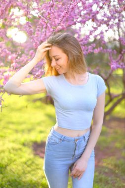 Çiçek açan ağaç arka plan ile genç kız.