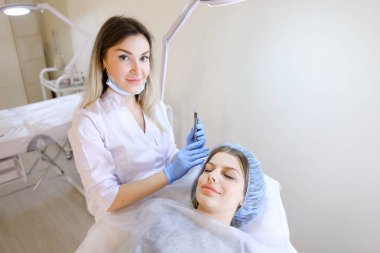 Kadın kişi makyaj güzellik uzmanı tarafından kaş dövme kalemi tarafından elde.