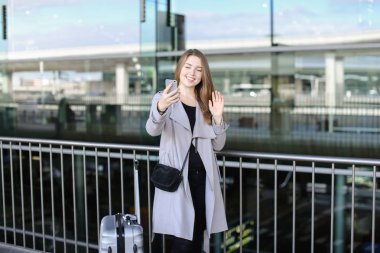 Genç kadın selfie smartphone valiz ve Havaalanı yakınında yapma.