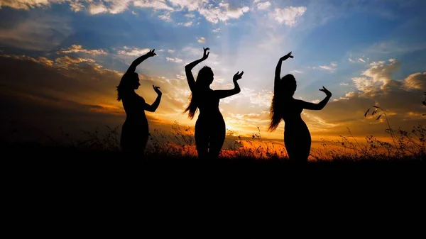 Silhouette femminili che fanno yoga in steppa, sfondo tramonto . — Foto Stock