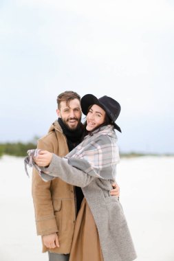 Mutlu gülümseyen kadın ve kat ve kış kar arka planda duran tulum giyen adam.