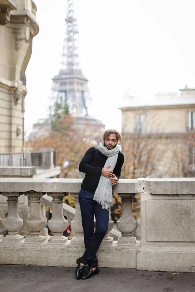 Jeune homme afro-américain debout près d'une rambarde en béton avec fond de Tour Eiffel à Paris . — Photo