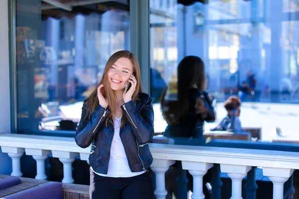 Mujer bonita hablando por teléfono inteligente en el café de la calle . — Foto de Stock