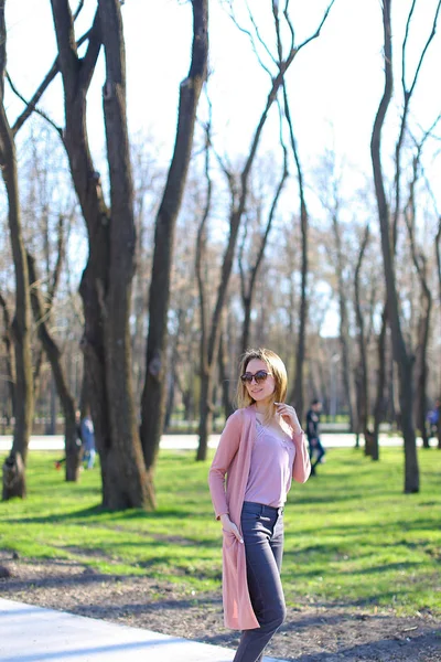Chica encantadora caminando en el parque y usando suéter largo . — Foto de Stock