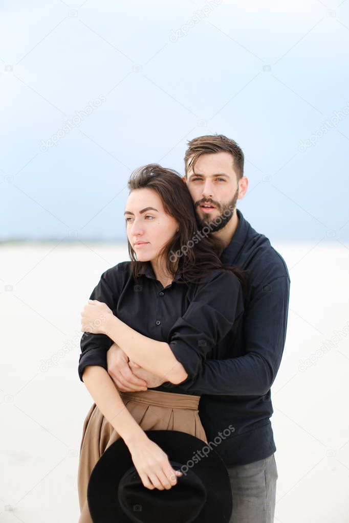 Portrait of european man hugging woman in monophonic background.