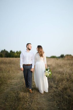 Damat bozkırda gelinle yürüyor..