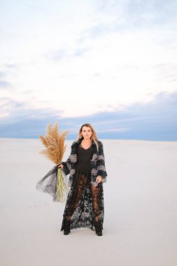 Kurumuş bitkilerle kaplı bozkırda kürk giyen kadın..