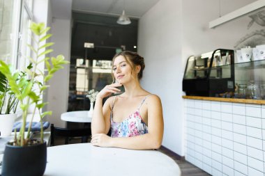 Pencerenin yanındaki kafede oturan hoş bir kız..