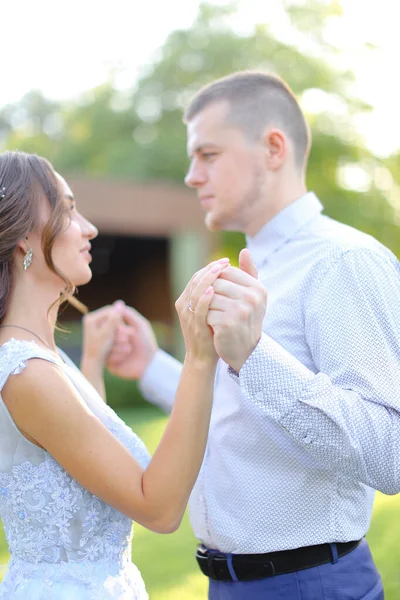 Jonge Kaukasische mooie bruid dansen met bruidegom in park. — Stockfoto