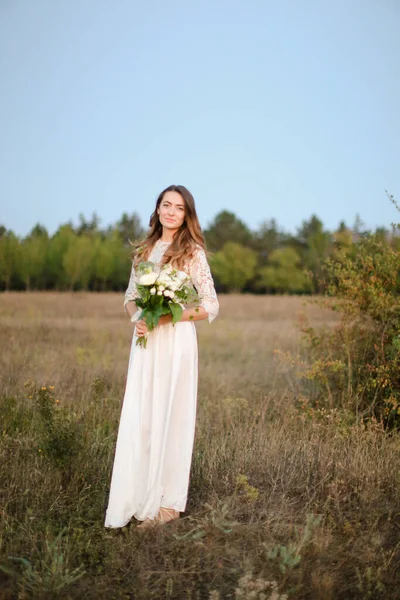 Λευκή νύφη με λευκό φόντο μπουκέτο σε φόντο στέπα. — Φωτογραφία Αρχείου