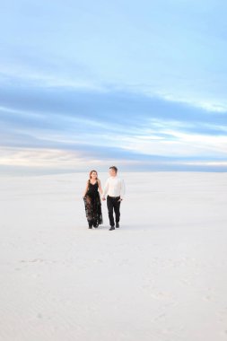 Siyah şeffaf elbiseli beyaz kadın kışın bozkırda yürüyor..