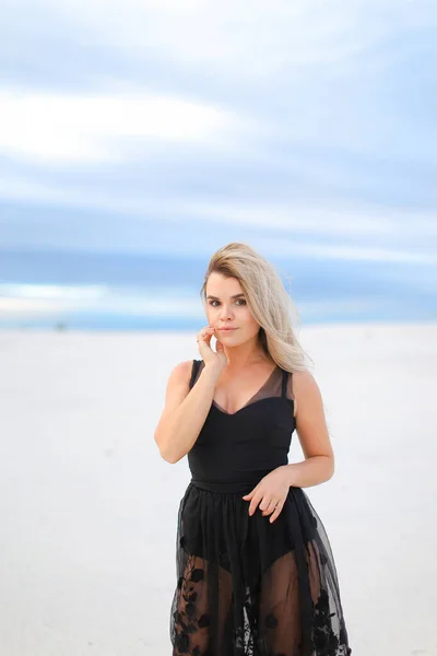 Joven chica encantadora con vestido negro transparente y caminar en la estepa de invierno . — Foto de Stock