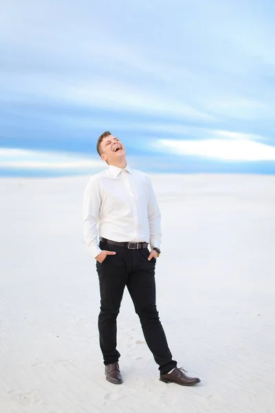 Jovem homem feliz de pé na estepe de inverno e vestindo camisa branca . — Fotografia de Stock