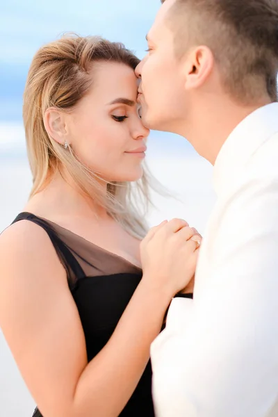 Ung man kysser kvinna i vit bakgrund. — Stockfoto