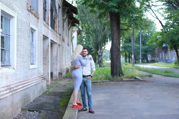 Gli amanti in posa per la fotografia, ridendo, in piedi uno accanto all'altro e abbracciandosi per strada . — Foto Stock