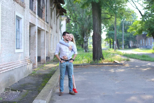 Amantes posando para fotografia, rindo, de pé ao lado uns dos outros e abraçando na rua . — Fotografia de Stock