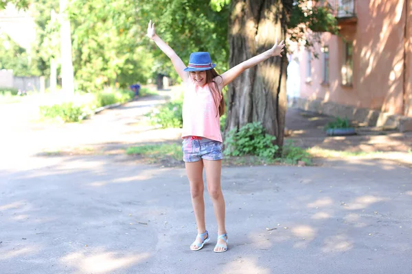 Красивая симпатичная девочка прыгает и веселится во дворе на улице . — стоковое фото