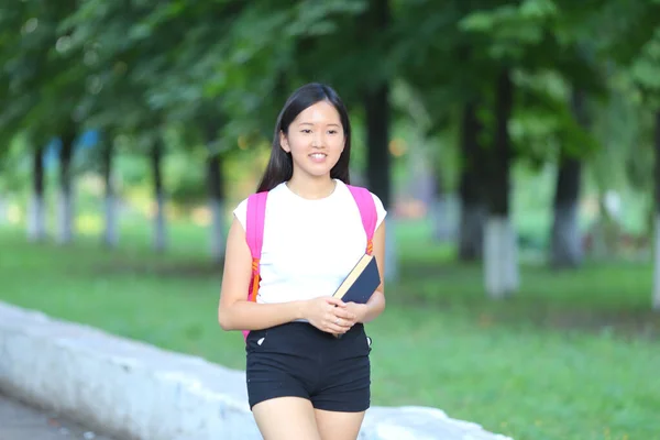 Ung flicka promenader i parken går gångart — Stockfoto