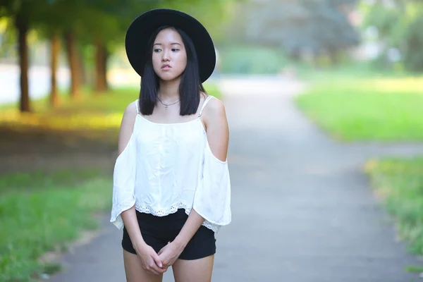 Красивая азиатка в шляпе смотрит в фотопортрет — стоковое фото