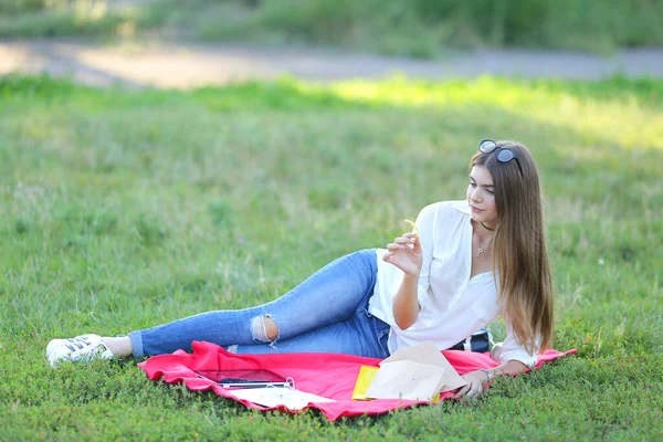 公園や食品のスナックで眼鏡で横になっている女性の作業 — ストック写真