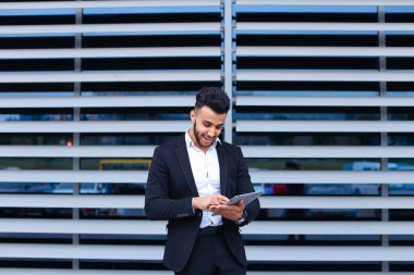 Genç Arap adam iş merkezinde online sipariş alışverişi tableti kullanıyor