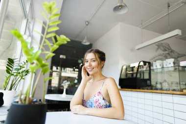 Genç ve çekici bir kadın kafede dinleniyor ve fotoğraf çekimi yapıyor..