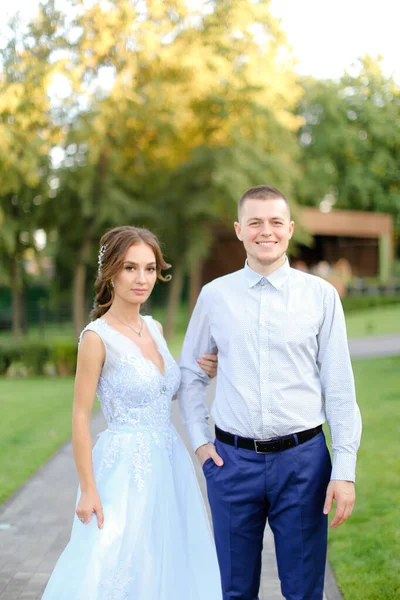 Joven novia de pie con novio caucásico en el jardín . — Foto de Stock