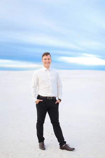 Young man standing in winter steppe and wearing white shirt. — Stock Photo, Image