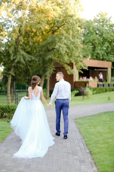 Πίσω όψη της καυκάσιας νεαρής νύφης και του γαμπρού να βγαίνουν έξω. — Φωτογραφία Αρχείου