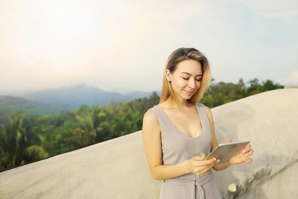 Chica rubia joven usando tableta con fondo de montaña, Tailandia . — Foto de Stock