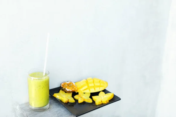 美味的新鲜果汁和芒果，盘面上有卡兰波拉，白色背景，带复制空间. — 图库照片