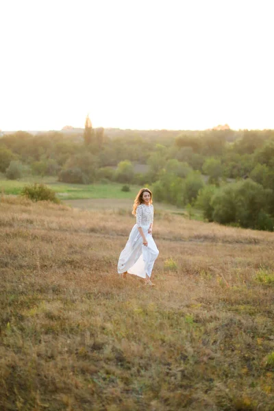 Caucasian european bride walking in steppe and wearing white dress. — Stock Photo, Image