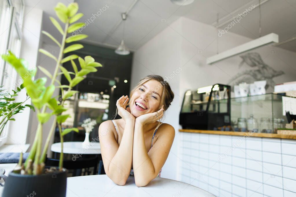 Young caucasian woman sitting at cafe and waiting boyfriend.