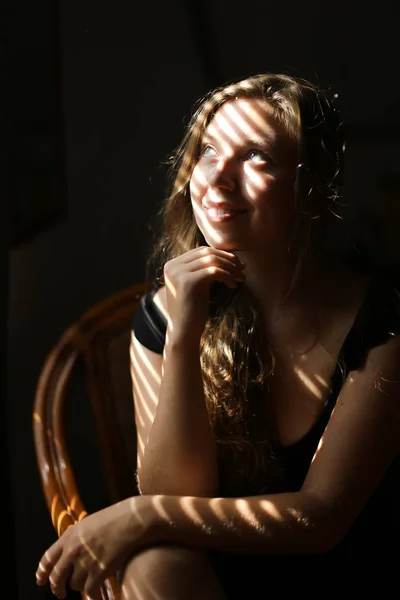 椅子に座っている若いかわいい女性の肖像画、縞模様の影. — ストック写真