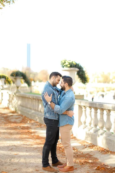 Caucasiano jovens gays andando no parque e abraçando em escadas de concreto . — Fotografia de Stock