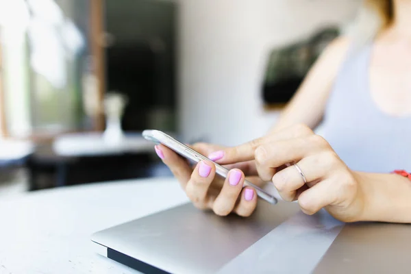 Close up hands chatting by smartphone near closed laptop. Stock Photo