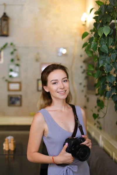 Portrait de fille souriante debout au café avec appareil photo . — Photo