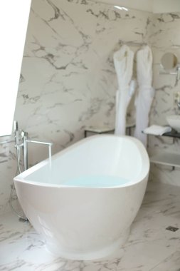 Modern beyaz banyo ve pencerenin yanında seramik banyo.