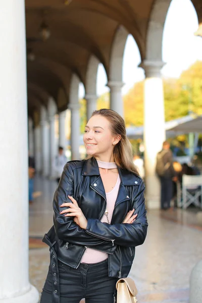 Femme caucasienne debout près de la colonne, la construction des arcs en arrière-plan . — Photo