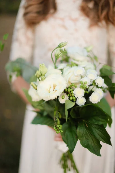 Nahaufnahme weißer Brautstrauß aus Blumen in den Händen der Braut. — Stockfoto