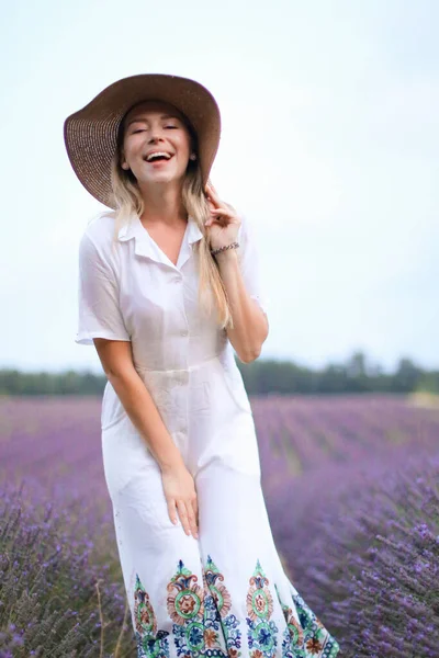 Junges Mädchen mit Hut und weißem Kleid steht auf Lavendelfeld, Provans. — Stockfoto