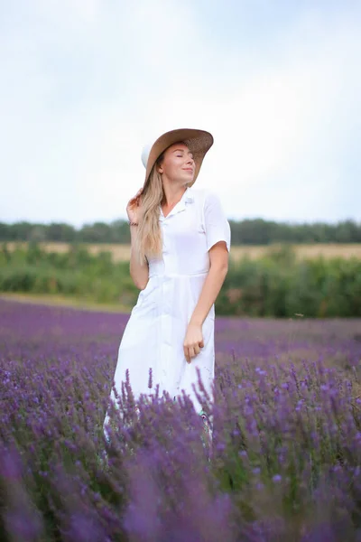 Junge kaukasische Mädchen mit Hut und weißem Kleid stehen auf Lavendelfeld, Provans. — Stockfoto