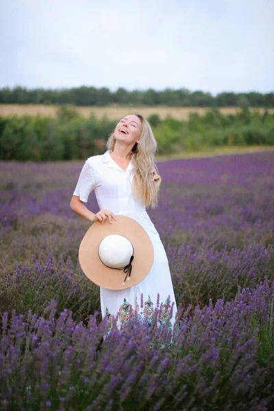 Junges Mädchen mit Hut und weißem Kleid steht auf Lavendelfeld, Provans. — Stockfoto