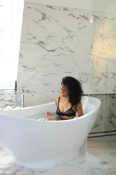 Afro american girl sitting in bath and wearing underwear. — Stock Photo, Image