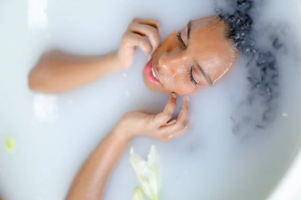 Primer plano retrato de la joven negra tomando baño de leche . — Foto de Stock