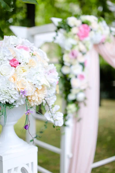 Närbild bukett blommor nära bröllop båge i parken. — Stockfoto