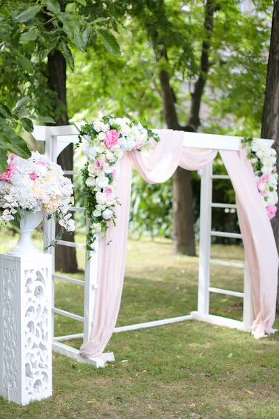 Arco de boda, decorado con increíbles rosas y sillas en el parque . — Foto de Stock