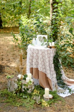 Sunağın yanında beyaz dekore edilmiş düğün masası..