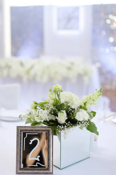 宴会テーブルの数2のフレームの近くのバラの花束. — ストック写真